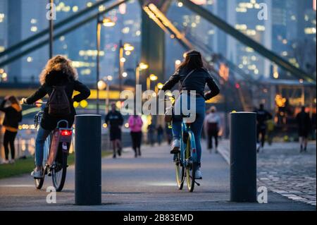 19 marzo 2020, Hessen, Francoforte sul meno: Due donne noleggio biciclette sulle rive del meno. Nonostante la pandemia di Corona, la gente sta passeggiando lungo le rive del Main e nel parco portuale parzialmente chiuso. Foto: Andreas Arnold/dpa Foto Stock