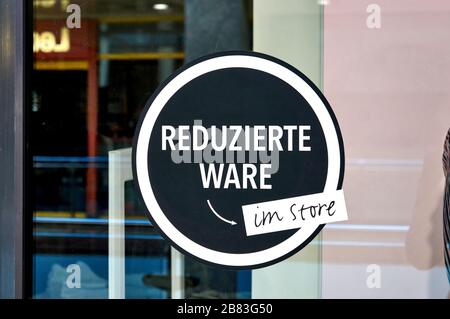 Grandi sconti in lettere tedesche su un segno nella vetrina del negozio. Foto Stock