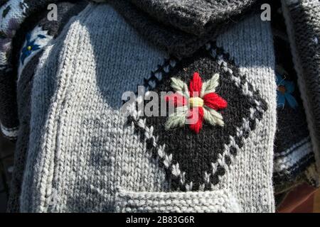 Un bel ornamento a forma di fiore su un maglione invernale. Foto Stock