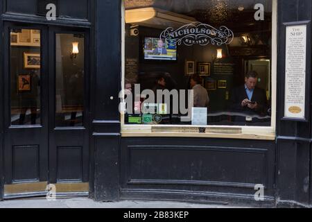 Mentre la pandemia di Coronavirus si diffonde in tutto il Regno Unito, le aziende e i luoghi di intrattenimento non sono già chiusi con la minaccia di perdita di posti di lavoro, lottano per rimanere aperti con le crescenti voci di blocco e restrizioni di viaggio intorno alla capitale. I bevitori di pub alla nave nel quartiere finanziario della capitale ignorano i consigli del governo per la limitazione delle riunioni sociali in luoghi pubblici come i pub abbnd bar, il 19 marzo 2020, a Londra, Inghilterra. Foto Stock