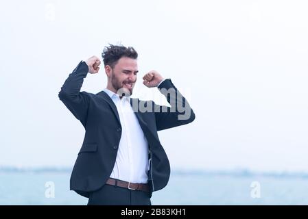 Un giovane uomo d'affari che è felice per il successo del business Foto Stock
