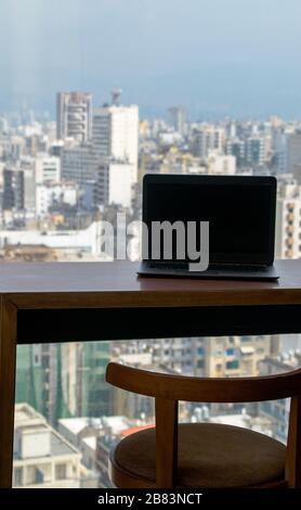 Scrivania con computer portatile al 21° piano e splendida vista sulla città Foto scattata a Beirut, Libano Foto Stock