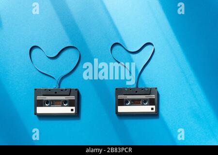 cassette con nastro magnetico a forma di cuore su sfondo blu Foto Stock