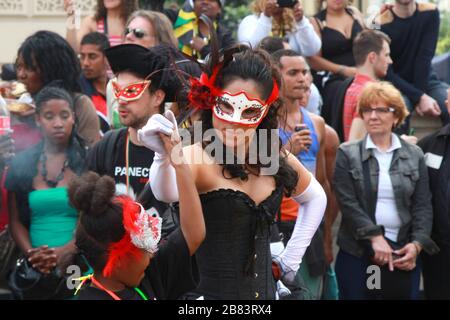 Donna in maschera decorata danzante con giovane ragazza al carnevale di Notting Hill a Londra Foto Stock