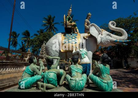 Battambang, Cambogia, Asia: Scultura dell'elefante bianco con gruppo di devoti nel tempio di Wat Tahm rai Foto Stock