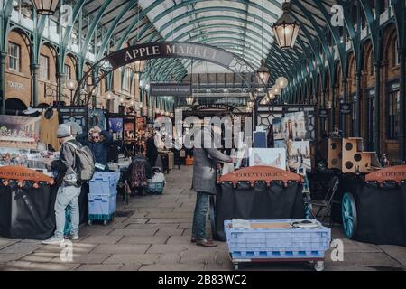 Londra, UK - 06 marzo 2020: Venditori e clienti presso le bancarelle di Apple Market all'interno di Covent Garden, uno dei siti turistici più popolari di Londra Foto Stock