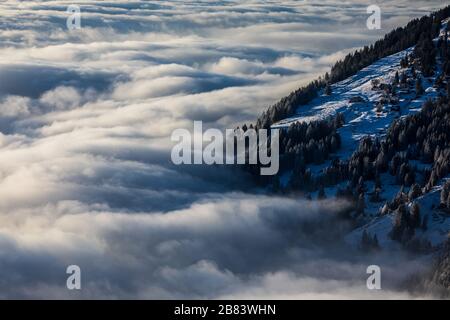 Splendido paesaggio apline. Alta montagna con nebbia e bella luce da sera. Foto Stock