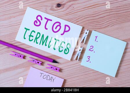 Nota di scrittura che mostra Stop termites. Concetto di affari per prevenire un piccolo insetto tropicale da danneggiare i legni colorati Clothespin carte remin vuoto Foto Stock