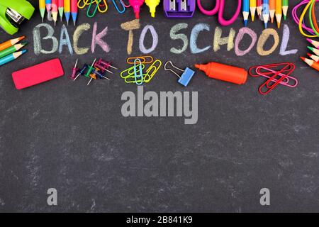 La scuola fornisce il bordo superiore con il ritorno alla scuola scritto in gesso colorato con contro uno sfondo della lavagna Foto Stock