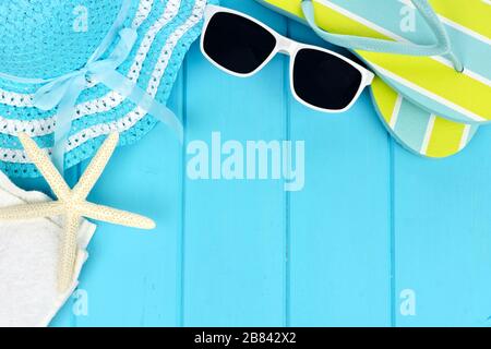 Angolo estivo bordo di oggetti da spiaggia su sfondo di legno blu Foto Stock