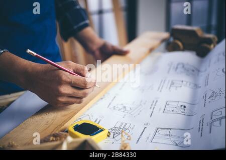 Carpenter lavorando su macchine per la lavorazione del legno in falegnameria shop. donna lavora in un negozio di falegnameria. Foto Stock