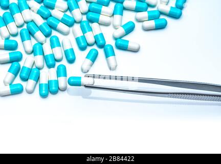 Forcipe prelevare la capsula bianco-blu dal gruppo di pillole. Farmaci scegliere. Selezione di farmaci antibiotici. Concetto di resistenza ai farmaci antibiotici. QA e QC Foto Stock