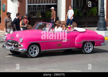 Donne turisti a l'Avana, Cuba facendo un giro in una classica Chevrolet rosa con un autista locale cubano. Opzione tour della città per le persone in vacanza. Foto Stock