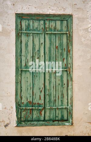 La finestra con il verde di legno intemperato in un vecchio edificio del villaggio Pano Lefkara. Cipro Foto Stock