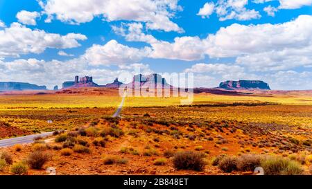 Autostrada 163 che conduce alle torreggianti Mitten Buttes di arenaria e Mesas della Monument Valley della Nazione Navajo al confine tra Utah e Arizona, Stati Uniti Foto Stock
