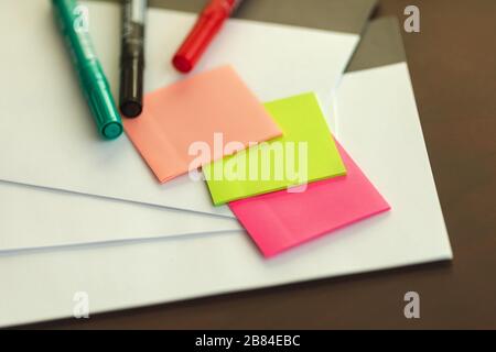 Adesivi colorati e pennarelli sul tavolo Foto Stock