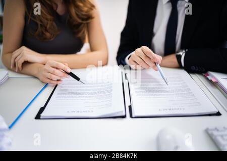 Close-up di due imprenditori della lavorazione manuale in contratto di carta sulla scrivania Foto Stock