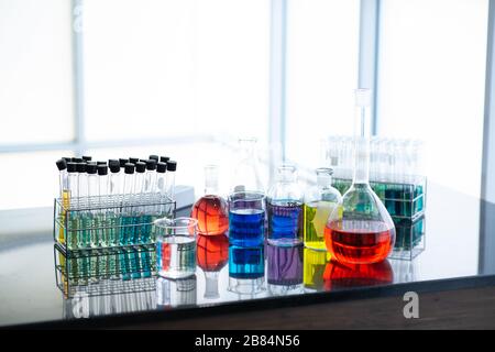 Campioni per test di laboratorio o laboratorio di ricerca medica o una soluzione con pipetta e vassoio per cellule a novantasei pozzetti con microscopi in background. Foto Stock