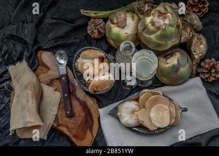 Sbucciare la palma e il succo di palma fresco davanti allo sfondo scuro. Vista dall'alto, Focus selettivo. Foto Stock