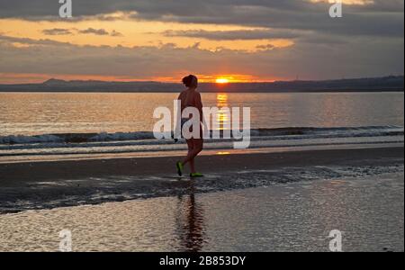 Portobello, Edimburgo, Scozia, Regno Unito. 20th Mar 2020. Temperatura 0 gradi centigradi come uno dei WanderWoman Scozia celebra Spring Equinox con una passeggiata all'alba lungo la riva. Durante gli Equinozi l'inclinazione della Terra (rispetto al Sole) è di 0° e a causa della sua durata del giorno e della notte è quasi uguale nel giorno Equinozio, cioè 12 ore. Foto Stock