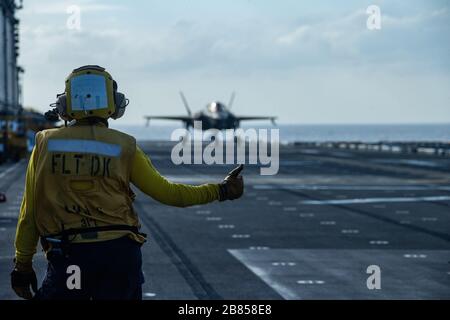 PHILIPPINE SEA (18 marzo 2020) un aereo da combattimento F-35B Lightning II con Marine Medium Tiltrotor Squadron 265 (rinforzato), 31st Marine Expeditionary Unit (MEU), viene autorizzato per il decollo da un marinaio a bordo di una nave d'assalto anfibia USS America (LHA 6). America, fiore all'occhiello dell'America Expeditionary Strike Group, il 31° team MEU, opera nell'area operativa della settima flotta statunitense per migliorare l'interoperabilità con alleati e partner e funge da forza di risposta pronta per difendere la pace e la stabilità nella regione dell'Indo-Pacifico. (Foto ufficiale del corpo marino degli Stati Uniti di CPL. Isaac Cantrell) Foto Stock