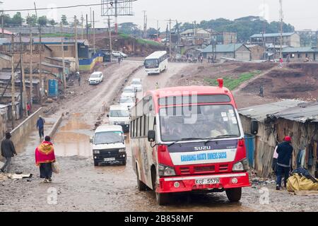 Un autobus (chiamato un matatu in Kenya) che attraversa la baraccopoli di Mathare, Nairobi, Kenya. In Kenya molti degli autobus sono di proprietà DI SACCO (risparmio e credito C Foto Stock