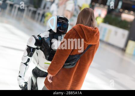 Giovane donna acquirente e consulente robot in negozio Foto Stock