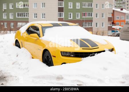 Lato anteriore dell'auto coperto di neve sul parcheggio. Omsk, Russia, 29.02.2020 Foto Stock