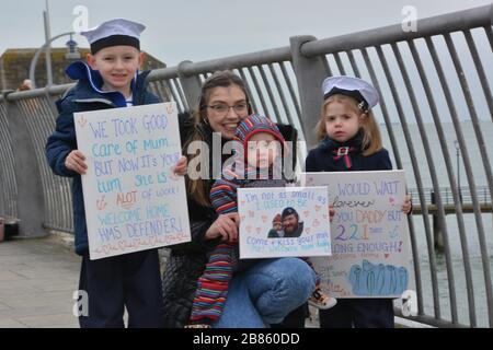 Ashleigh Jefferson e i bambini, Oscar, Six, Spencer, One e Myla, Three, si preparano ad accogliere Ryan Jefferson, leader Hand, di Newcastle-upon-Tyne, che sta tornando alla base navale di Portsmouth a bordo di HMS Defender dopo sette mesi di spiegamento in Medio Oriente. Il tradizionale raduno è stato cancellato a causa di Covid-19 così le famiglie si sono radunate sulle pareti del porto per far tornare a casa i loro cari. Foto Stock