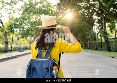 Bei giovani turisti asiatici, camicie gialle, cappelli di paglia, zaini che viaggiano in un parco in Thailandia. Ha molta passione e felicità. Foto Stock