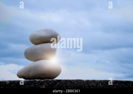 Le pietre che sono impilate insieme sono paragonabili alla meditazione di yoga. Lo sfondo è il cielo del mattino, i colori luminosi sono una buona energia. Bilanciato, po Foto Stock