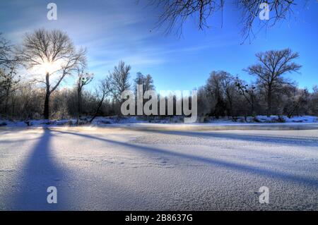 Incantevole paesaggio invernale splendidi snowdrift si trovano nella foresta tra gli alberi in una soleggiata giornata invernale ghiacciata. Il concetto di duro ma bello Foto Stock