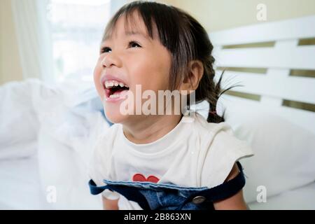 Le ragazze asiatiche sorridono e ridono molto felicemente. Sembrava molto allegra dopo aver dormito pienamente. Ha ricevuto un ottimo sguardo, una fa ben curata Foto Stock