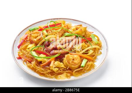 Singapore Mei Fun in piatto isolato su sfondo bianco. Singapore Noodles è un piatto di cucina cinese con tagliatelle di riso, gamberi, maiale char siu, carota, r Foto Stock