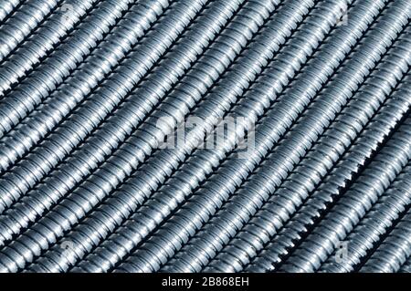 Primo piano di un enorme fascio di bobina di protezione da 10 mm interconnessa in uno stabilimento industriale o industriale. Enorme mazzo di tubi flessibili in metallo interconness Foto Stock