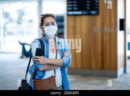 Restrizioni di viaggio per l'epidemia di coronavirus. Viaggiatori con maschera facciale all'aeroporto internazionale interessati da cancellazioni di voli e divieto di viaggio. COVID-19 Foto Stock
