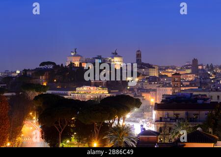 Foto notturna di lunga durata della magnifica città di Roma visto al tramonto da un giardino sulle colline, sono visibili alcuni monumenti famosi Foto Stock