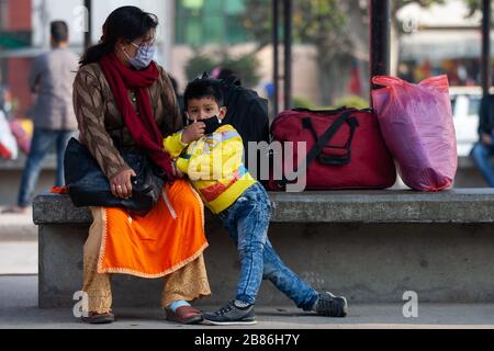 Una donna con il suo bambino che indossa maschere protettive attendono a bordo di un autobus a lunga distanza tra Coronavirus Threats.Nepalese governo ha deciso di chiudere i luoghi pubblici come scuole, cinema, night club, club di salute, centri culturali e zona sportiva, Dal 19 marzo al 30 aprile 2020 nell'ambito di misure precauzionali contro la diffusione del virus della corona Covid-19. Foto Stock