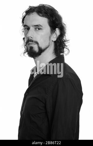 Vista del profilo di un bell'uomo d'affari barbuto che guarda la macchina fotografica Foto Stock