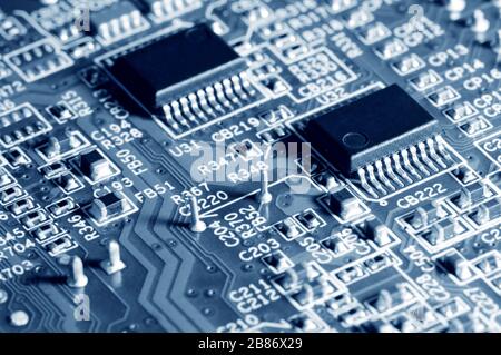 Scheda a circuito stampato elettronica a primo piano con microchip da un dispositivo domestico o da un computer portatile elettronico e dispositivi complessi. Concetto di microchip e futuro t Foto Stock
