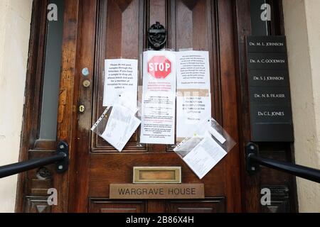 Hereford, Herefordshire, Regno Unito - Venerdì 20 Marzo 2020 - l'ingresso ad un ambulatorio medici è ora coperto in segnali di avvertimento relativi alla crisi Coronavirus Covid-19 - Foto Steven Maggio / Alamy Live News Foto Stock