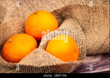 Succosi tangerini maturi su uno sfondo di tessuto omespun ruvido. Primo piano Foto Stock