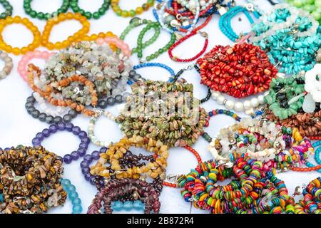 La pietra colorata è usata per fare i bracelets bei. È una credenza religiosa della gente tailandese che avrà buona fortuna per la vendita sul mercato locale dentro Foto Stock