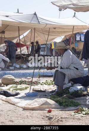 Essaouria, Marocco - Settembre 2017: Un contadino siede waitnig per vendere i suoi prodotti al mercato aperto settimanale berbero al di fuori di Essaouira in Marocco. Donne ra Foto Stock