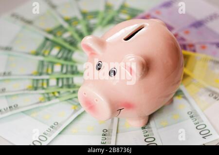 piggy banca e euro fatture di diverse denominazioni Foto Stock