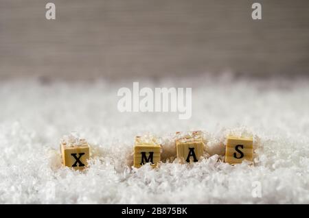 x mas parola fatta di lettere su cubi di legno su fondo neve 3 Foto Stock