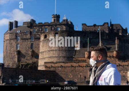 Edimburgo, Regno Unito. 20 Marzo 2010. Un turista che indossa una maschera in un castello di Edimburgo insolitamente tranquillo a causa dell'epidemia di Covid19. Credit: Richard Newton/Alamy Live News Foto Stock