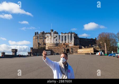 Edimburgo, Regno Unito. 20 Marzo 2010. Un turista che indossa una maschera in un castello di Edimburgo insolitamente tranquillo a causa dell'epidemia di Covid19. Credit: Richard Newton/Alamy Live News Foto Stock