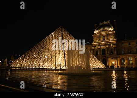 Louvre e Piramide di vetro di notte Foto Stock