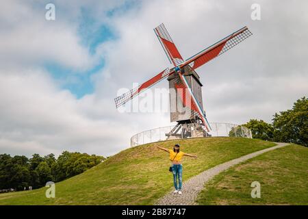 Brugge Belgium, casa colorata nella città vecchia di Brugge , giovane donna libera in città dal vecchio mulino a vento, Bruges, Belgio. Vento di Sint Janshuismolen Foto Stock